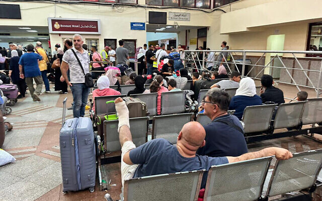 Des passagers évacuant la bande de Gaza arrivent dans la partie égyptienne du poste frontière de Rafah avec l'enclave côtière, le 12 novembre 2023, dans le cadre de la guerre entre Israël et le Hamas. (Crédit : AFP)
