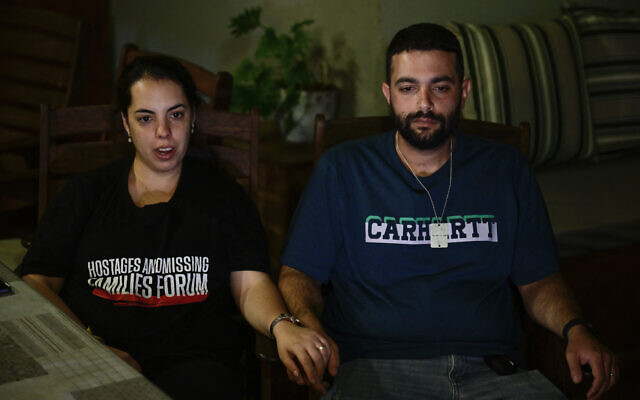 Omer et Zemer Weiss, fils et belle-fille de Shmulik et Yehudit Weiss, tués par le Hamas, en interview dans leur maison de Moshav Olesh, le 17 novembre 2023. (Crédit : JOHN MACDOUGALL / AFP)