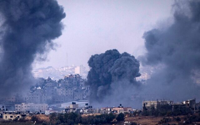 De la fumée s'élevant au-dessus de bâtiments lors d'une frappe israélienne sur la bande de Gaza, sur une photo prise depuis le sud d'Israël, le 19 novembre 2023. (Crédit : Kenzo Tribouillard/AFP)
