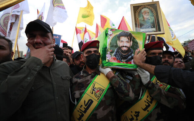 Des Irakiens portent le cercueil de Fadel al-Maksusi, un combattant des Kataeb Hezbollah qui faisait également partie du groupe de la Résistance islamique en Irak, le groupe qui a revendiqué toutes les attaques récentes contre les troupes américaines en Irak et en Syrie, lors d'un enterrement à Bagdad le 21 novembre 2023. (Crédit : AHMAD AL-RUBAYE / AFP)
