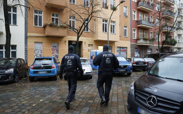 Des policiers se tiennent devant une maison dans le quartier de Friedrichshain à Berlin, lors d'une perquisition contre le Hamas et Samidoun, tous deux interdits dans le pays, le 23 novembre 2023. (rédit : Odd ANDERSEN/AFP)