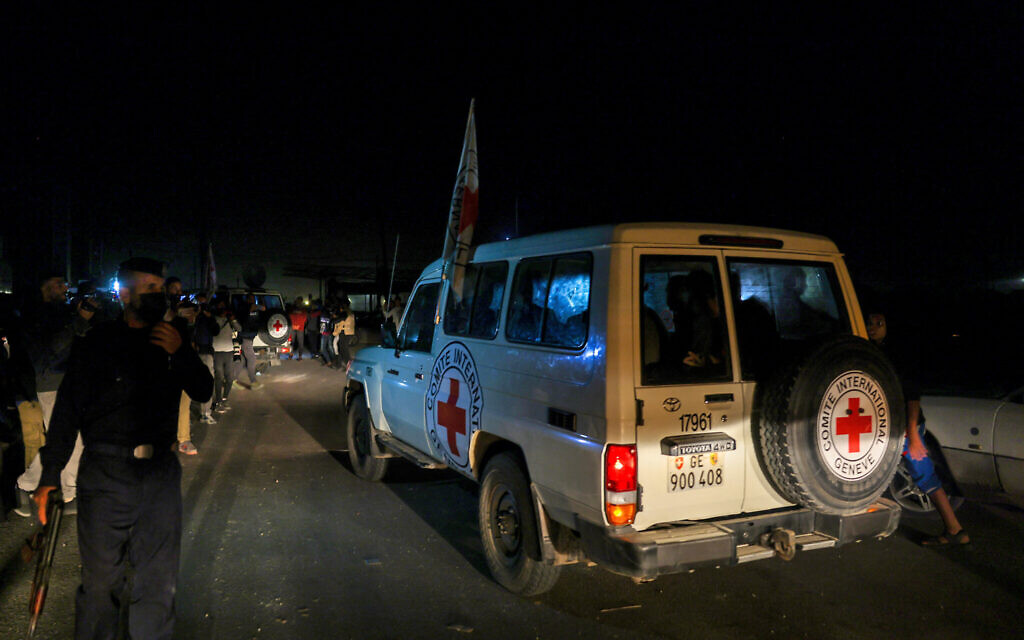 Des véhicules de la Croix-Rouge internationale transportant vraisemblablement des otages israéliens relâchés par le groupe terroriste palestinien du Hamas dans le cadre d'un accord incluant la libération de prisonniers palestiniens, traversant le poste-frontière de Rafah, dans la bande de Gaza en direction de l'Égypte, le 24 novembre 2023. (Crédit : Mohammed Abed/AFP)
