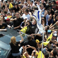 Le député argentin et candidat présidentiel de La Libertad Avanza Javier Milei brandit le drapeau national d'Israël lors d'un rassemblement électoral, le 16 octobre 2023, à Lomas de Zamora, province de Buenos Aires, Argentine. (Crédit : Luis ROBAYO / AFP)