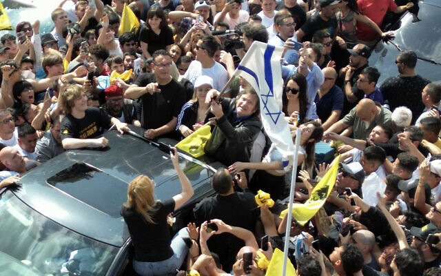 Le député argentin et candidat présidentiel de La Libertad Avanza Javier Milei brandit le drapeau national d'Israël lors d'un rassemblement électoral, le 16 octobre 2023, à Lomas de Zamora, province de Buenos Aires, Argentine. (Crédit : Luis ROBAYO / AFP)