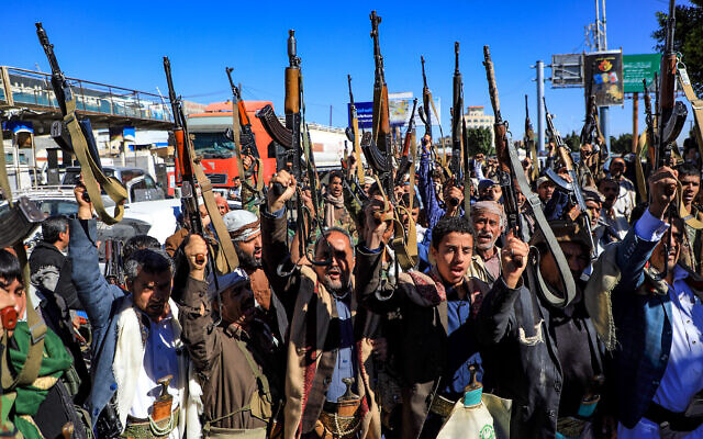 Des partisans yéménites des rebelles Houthi soutenus par l'Iran brandissant leurs armes lors d'un rassemblement dans la capitale Sanaa, le 27 janvier 2022. (Crédit : Mohammed Huwais/AFP)