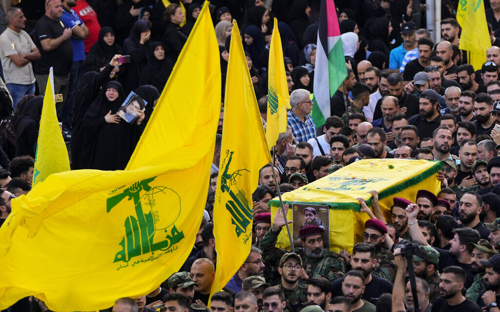Des terroristes du Hezbollah portant le cercueil de leur camarade, Qassim Ibrahim Abu-Taam, qui a été tué le long de la frontière sud du Liban avec Israël, lors de sa procession funéraire dans la banlieue sud de Beyrouth de Dahiyeh, au Liban, le 6 novembre 2023. (Crédit : Hassan Ammar/AP Photo)