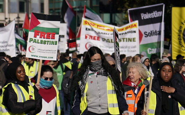 Des manifestants brandissant des pancartes lors d'une grande manifestation pro-palestinienne, à Londres, le 11 novembre 2023. (Crédit : Alberto Pezzali/AP Photo)