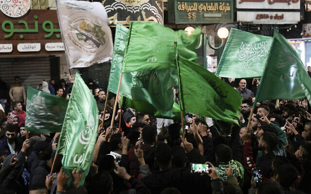 Des Palestiniens brandissant des drapeaux du Hamas célébrant la libération des prisonniers sécuritaires palestiniens dans le cadre d'un accord conclu entre Israël et le Hamas, dans la ville de Naplouse, en Cisjordanie, le 24 novembre 2023. (Crédit : Majdi Mohammed/AP Photo)