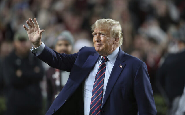 Le candidat républicain à la présidentielle et ancien président des États-Unis Donald Trump salue la foule à la mi-temps d'un match de la NCAA entre la Caroline du sud et Clemson à Columbia, en Caroline du sud, le 25 novembre 2023. (Crédit : Artie Walker Jr./AP)