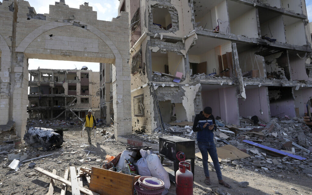 Des Palestiniens parmi des décombres de bâtiments détruits à Gaza City, le 28 novembre 2023. (Crédit : AP/Adel Hana)