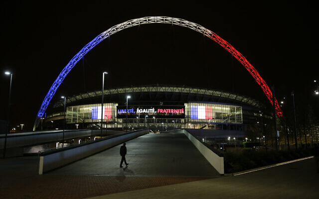L'arche du stade de Wembley illuminée aux couleurs du drapeau français au-dessus des mots traduits du français "Liberté, Égalité, Fraternité" en signe de respect pour les victimes des attentats meurtriers de Paris, à Londres, le 16 novembre 2015. (Crédit : Matt Dunham/AP)