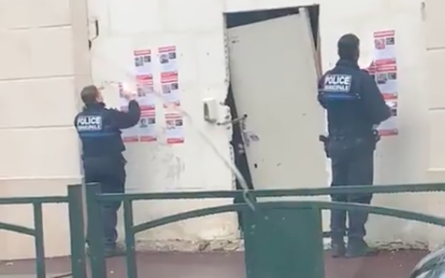 Des policiers du Raincy vus arrachant des affiches pour les otages, au Raincy, en octobre 2023. (Crédit : Riveline / Twitter)
