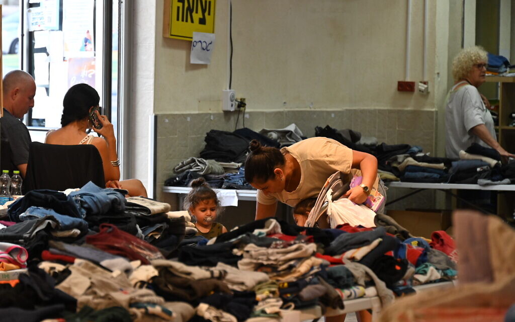 Nofar Baruchi de Beit Hagedi cherchant des vêtements d'enfants d’occasion dans un centre de distribution pour les personnes évacuées, à Eilat, en Israël, le 31 octobre 2023. (Crédit : Canaan Lidor/Times of Israel)