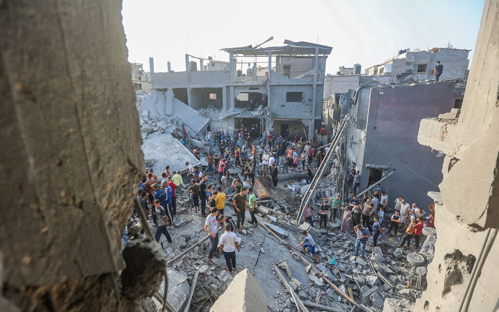 Des Palestiniens dans les décombres d'un bâtiment détruit dans le centre e Gaza city après une frappe israélienne, le 5 novembre 2023. (Crédit : Atia Mohammed/Flash90)