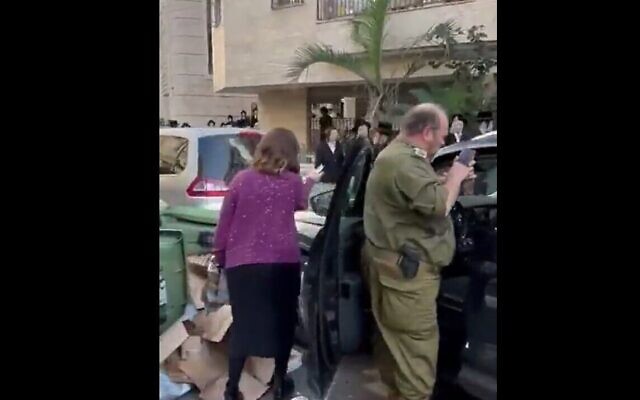 Un soldat réserviste haredi, à droite, pris à partie par des extrémistes ultra-orthodoxes dans la ville de Bnei Brak, le 20 novembre 2023. (Crédit : Capture d'écran d'une vidéo Twitter : utilisée conformément à l'article 27a de la loi sur le droit d'auteur)