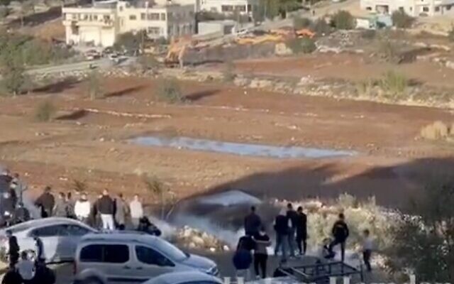 Les forces de sécurité israéliennes tirant des gaz lacrymogènes sur les Palestiniens qui se rassemblent devant la prison d'Ofer, en Cisjordanie, le 24 novembre 2023. (Crédit : Capture d'écran X)
