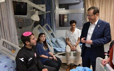 Le président Isaac Herzog rendant visite à des soldats blessés, à l'hôpital Ichilov, à Tel Aviv, le 8 novembre 2023. (Crédit : Amos Ben Gershom/GPO)