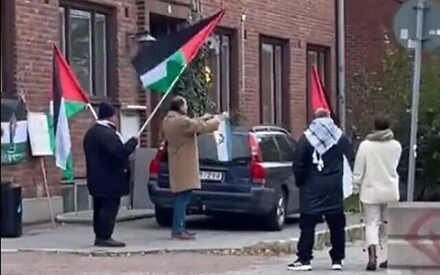 Un manifestant brûle un drapeau israélien aux abords d'une synagogue de Malmo, le 4 novembre 2023. (Crédit : Conseil des communautés juives suédoises)