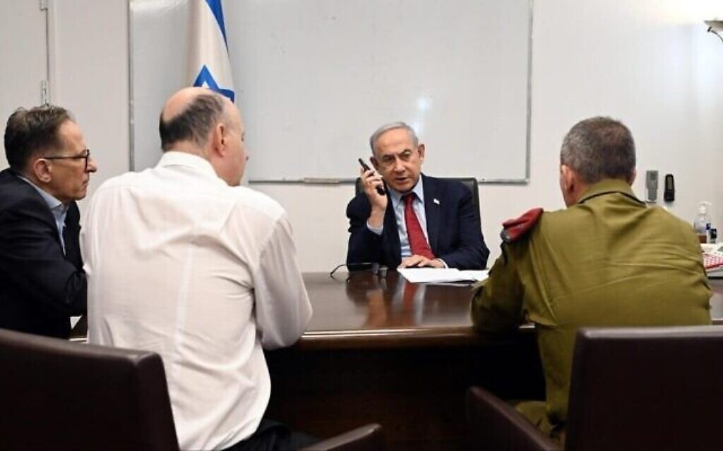 Le Premier ministre Benjamin Netanyahu s'entretient au téléphone avec le chef du Mossad, David Barnea, à Doha, au Qatar, le 28 novembre 2023. Le chef d'état-major Tzachi Braverman, à l'extrême gauche, le chef du Conseil de sécurité nationale Tzachi Hanegbi, au centre, et le secrétaire militaire, le général de division Avi Gil, participent également à l'appel. (Crédit : Haim Zach/GPO)