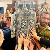 Les résidents du kibboutz Beeri et des visiteurs inaugurent un rouleau de Torah dans la synagogue du kibboutz en mémoire d'Amit Man, tuée, avec de nombreux autres, par les terroristes du Hamas le 7 octobre, le 27 novembre 2023. (Autorisation : Famille d'Amit Man)
