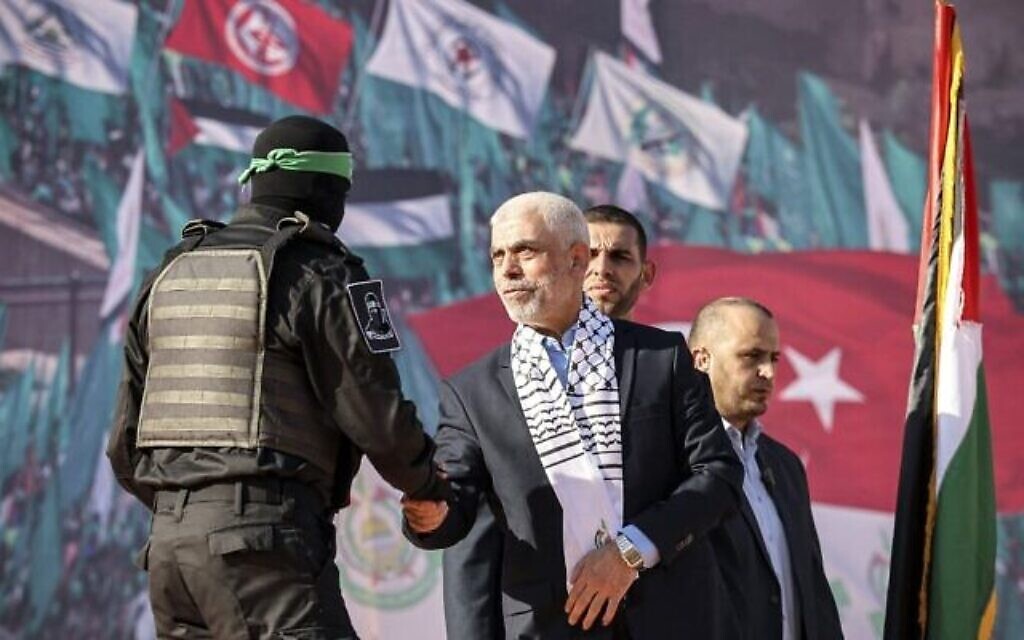 Yahya Sinwar, au centre, chef du Hamas dans la bande de Gaza, serrant la main d'un terroriste palestinien du Hamas lors d'un rassemblement marquant le 35e anniversaire de la fondation du du groupe terroriste palestinien, à Gaza City, le 14 décembre 2022. (Crédit : Mohammed Abed/AFP)