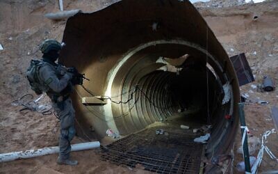 Un soldat se tenant à l'entrée d'un grand tunnel du Hamas trouvé près du poste frontalier d'Erez dans le nord de la bande de Gaza, sur une photo diffusée le 17 décembre 2023. (Crédit : Armée israélienne)