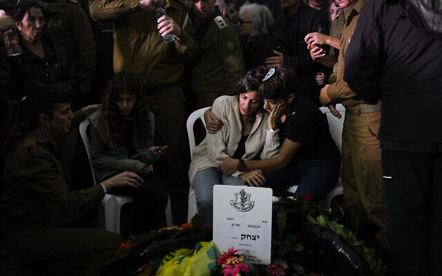La famille et les amis de l'officier de Tsahal, le colonel Itzhak Ben Basat, pleurent sur sa tombe à ses funérailles à Kfar Tavor, en Israël, le 13 décembre 2023. (Crédit : Ariel Schalit/AP)