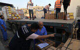 Des employés déchargent un camion de fournitures médicales de l'Organisation mondiale de l SAnté, à l'hôpital Nasser de Khan Younès, dans la bande de Gaza, le 23 octobre 2023. (Crédit : Mahmud HAMS / AFP)