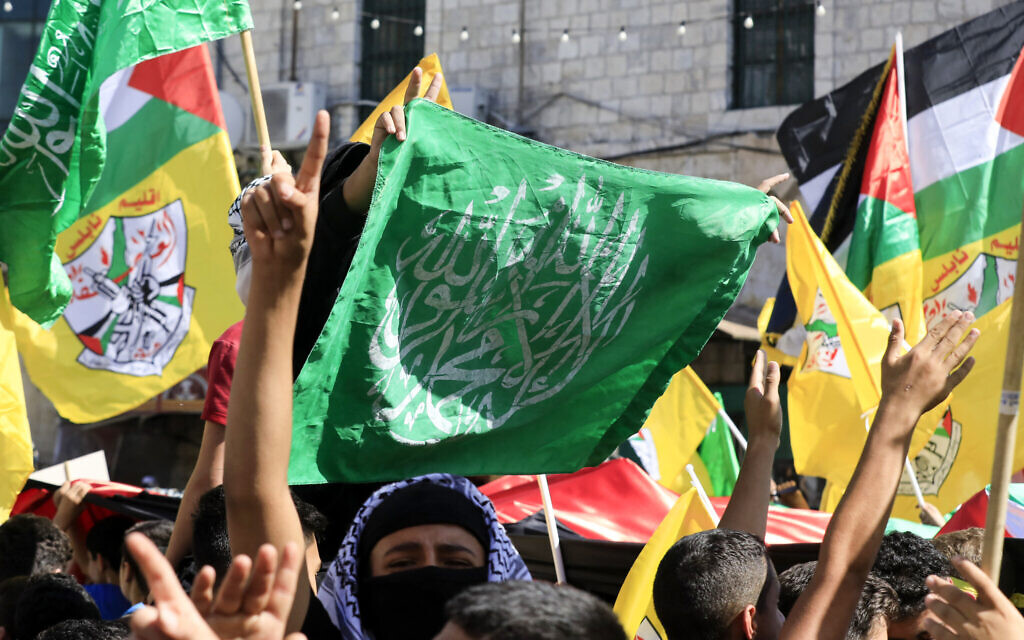 Des Palestiniens brandissant des drapeaux palestiniens, du Hamas et du Fatah lors d'une manifestation en soutien à la bande de Gaza à Naplouse, en Cisjordanie, le 26 octobre. (Crédit :  Zain Jaafar/AFP)