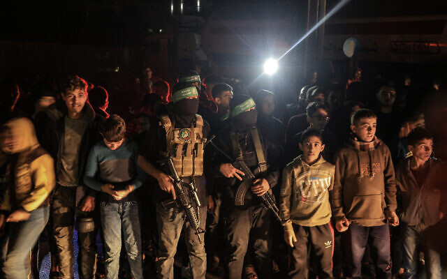 Des enfants à coté de terroristes du Hamas, à Khan Younès, dans la bande de Gaza, le 29 novembre 2023. (Crédit : AFP)
