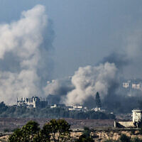 De la fumée s'élevant des bâtiments après avoir été touchés par des frappes israéliennes apparentes à Gaza, le 1er décembre 2023. (Crédit : John MacDougall/AFP)