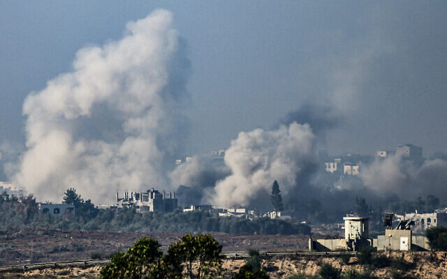 De la fumée s'élevant des bâtiments après avoir été touchés par des frappes israéliennes apparentes à Gaza, le 1er décembre 2023. (Crédit : John MacDougall/AFP)