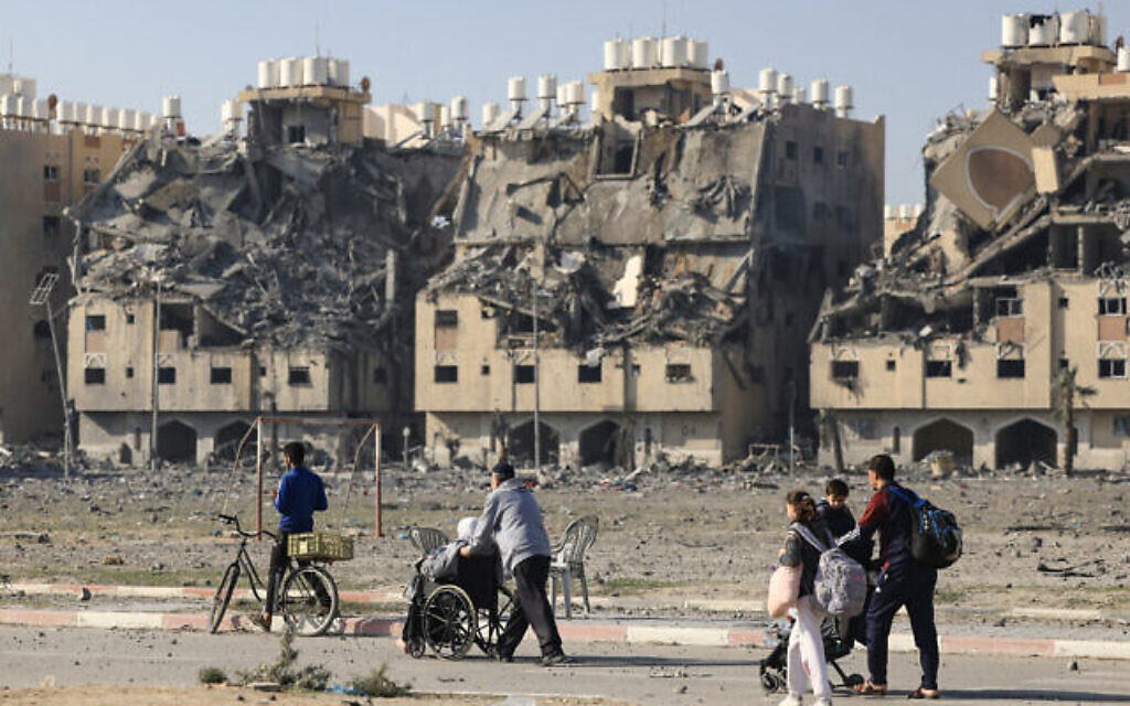 Des habitants du complexe résidentiel Hamad Town, financé par le Qatar, fuyant avec quelques biens suite à une frappe israélienne, à Khan Younès, dans le sud de la bande de Gaza, le 2 décembre 2023. (Crédit : Mahmud Hams/AFP)