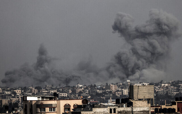 De la fumée s'élevant au-dessus des bâtiments lors des frappes israéliennes sur Khan Younès, dans le sud de la bande de Gaza, depuis Rafah, le 9 décembre 2023. (Crédit : Mahmud Hams/AFP)