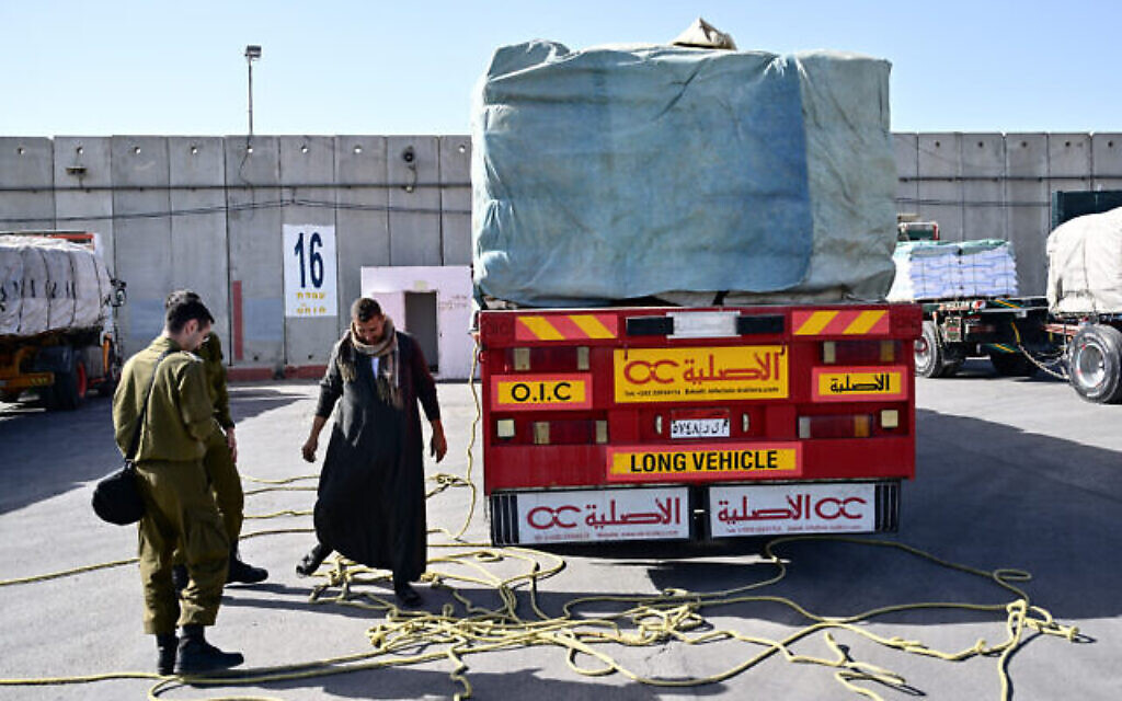 Le 22 décembre 2023, des soldats israéliens inspectent des camions d’aide humanitaire arrivant d’Égypte, du côté israélien du poste frontalier de Kerem Shalom avec le sud de la bande de Gaza, en pleine guerre entre Israël et le groupe terroriste palestinien Hamas. (Crédit : Alberto Pizzoli/AFP)