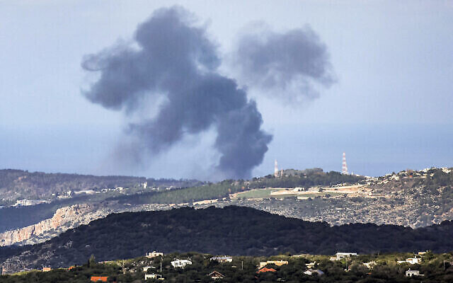 Des volutes de fumée s’élevant à l'horizon le long des collines de la région de Naqura, dans le sud du Liban, suite aux frappes israéliennes, le 24 décembre 2023. (Crédit : Jalaa Marey/AFP)