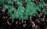 Des personnes agitent des drapeaux du Hamas tout en criant des slogans lors d'une manifestation pro-palestinienne et pro-Hamas après la prière du vendredi devant la mosquée de Beyazit à Istanbul, en Turquie, le 24 novembre 2023. (Crédit : AP/Francisco Seco)