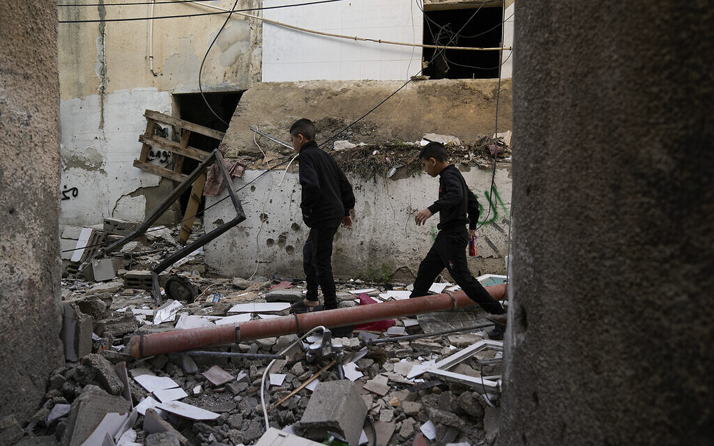 Des Palestiniens dans un bâtiment endommagé suite à une opération militaire israélienne, à Jénine, le 26 novembre 2023. (Crédit : Majdi Mohammed/AP Photo)