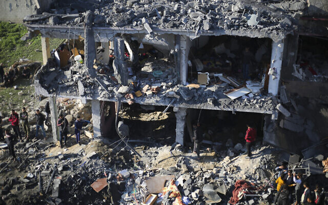 Des Palestiniens inspectent les dégâts après une frappe israélienne à Rafah, dans le sud de la bande de Gaza, le19 décembre 2023. (Crédit : AP Photo/Hatem Ali)
