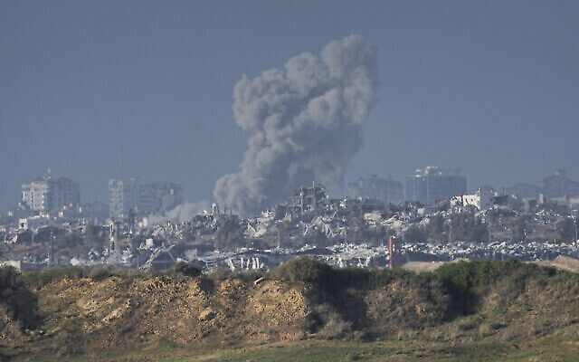 De la fumée s'élève après une frappe israélienne dans la bande de Gaza, vue du sud d'Israël, dimanche 24 décembre 2023. (Crédit : AP/Ariel Schalit)