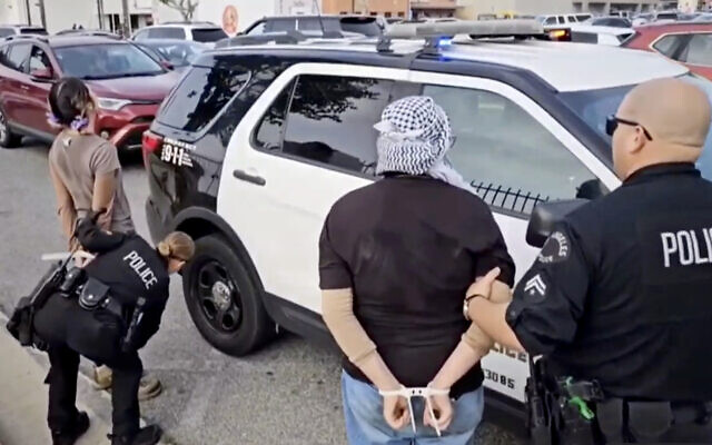 Cette image vidéo fournie par KABC-TV montre Des manifestants arrêtés par des officiers de police de Los Angeles, près de l'aéroport international de Los Angeles, le 27 décembre 2023. (Crédit : KABC-TV via AP)