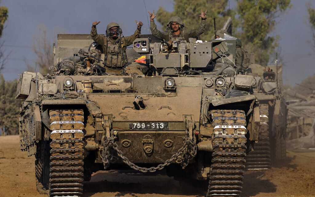 Des véhicules de l'armée arrivent à une zone de rassemblement après des combats dans la bande de Gaza, dans le sud d'Israël, le 30 décembre 2023.(Crédit : AP/Tsafrir Abayov)