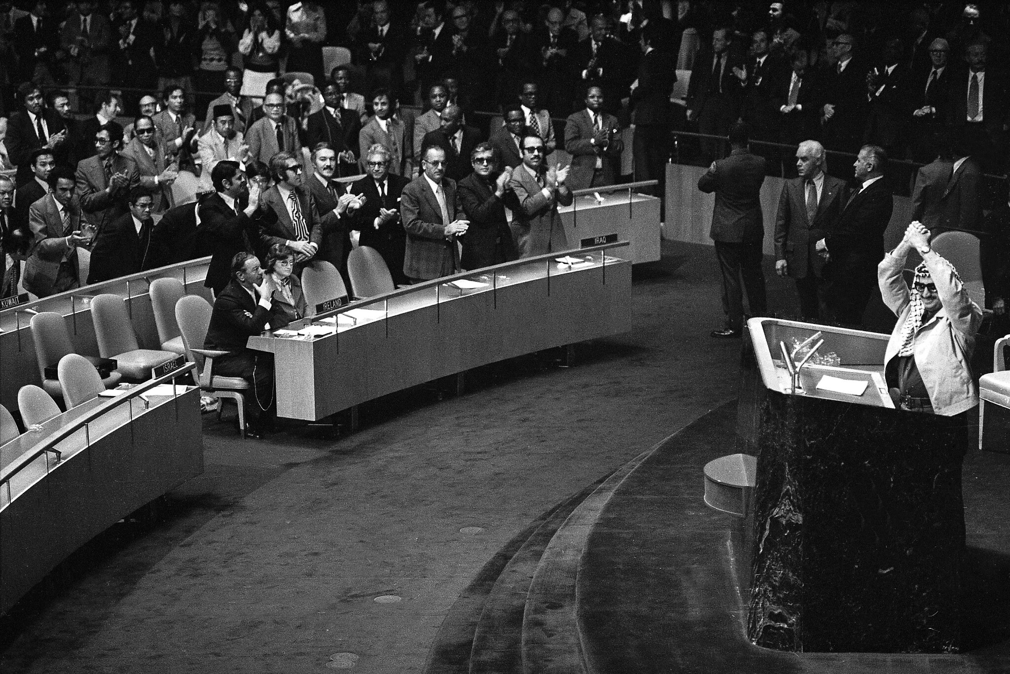 Yasser Arafat lève les mains alors que certains délégués lui réservent une standing ovation devant l'Assemblée générale des Nations unies à New York, le 14 novembre 1974. (Crédit : AP Photo)