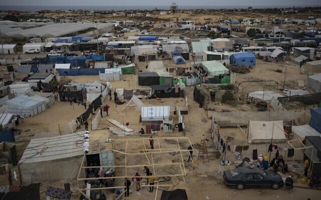 Des Palestiniens déplacés par l'incursion terrestre israélienne contre le Hamas dans la bande de Gaza installant un camp de tentes dans la zone d'al-Mawasi, le 7 décembre 2023. (Crédit : Fatima Shbair/AP Photo)