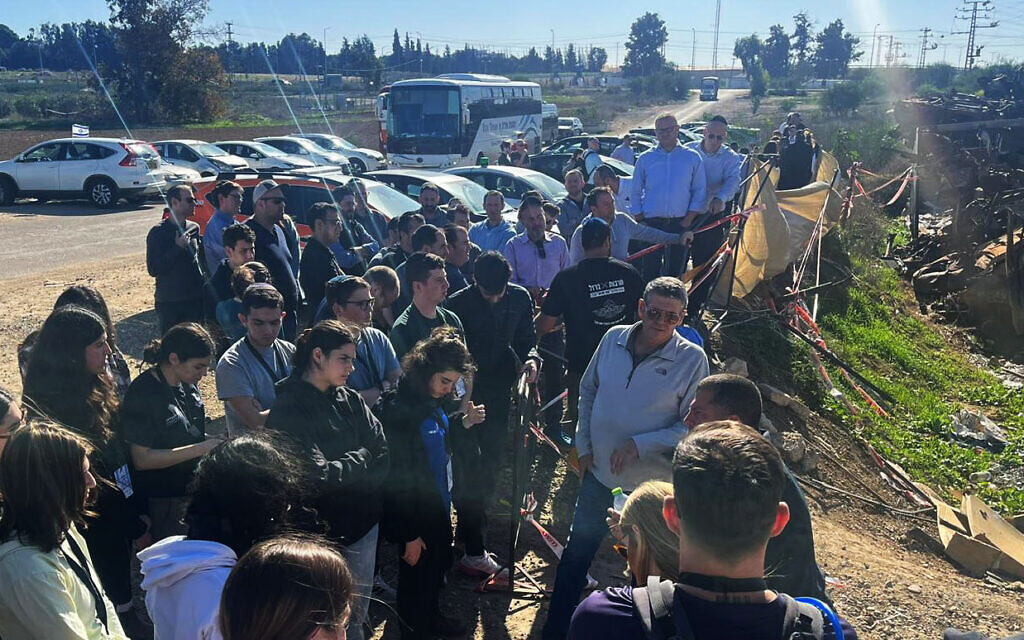 Des étudiants d'universités nord-américaines visitant le cimetière de voitures, rempli de véhicules de victimes du Festival Supernova, dans le sud d'Israël, le 26 décembre 2023. (Crédit : Boursiers de la Hasbara)