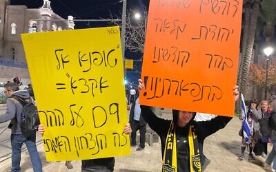 Des participants brandissent des pancartes lors d’une marche d’extrême droite à Jérusalem, le 7 décembre 2023. (Crédit : Jeremy Sharon/Times of Israel)