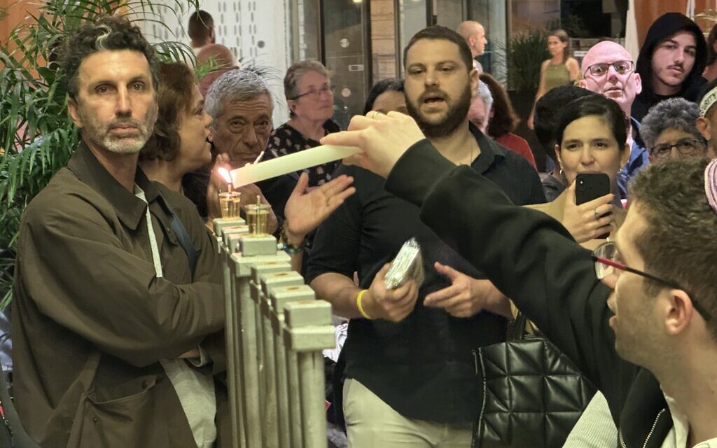 Les membres du kibboutz Miflasim allument des bougies pour Hanoukka à l'hôtel Dan Accadia de Herzliya, le 8 décembre 2023. (Autorisation :  Kibbutz Miflasim)