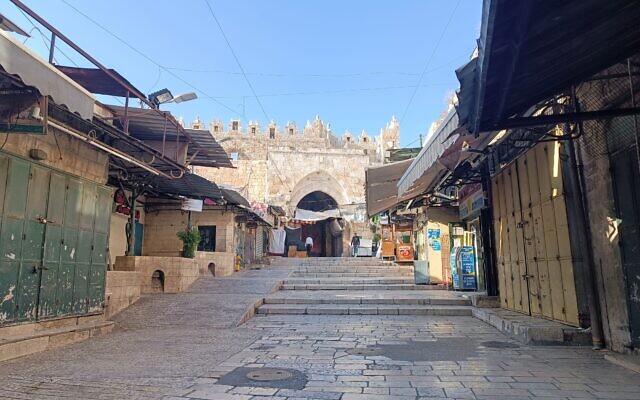 La rue commerciale menant à la Porte de Damas à l'intérieur de la Vieille Ville de Jérusalem, habituellement un site animé avec un marché alimentaire, vide pendant une grève générale en solidarité avec les Palestiniens de Gaza, 11 décembre 2023 (Crédit : Gianluca Pacchiani / Times of Israel)