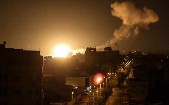 Des flemmes et de la fumée s'élevant au-dessus des bâtiments de Gaza City alors qu'Israël a lancé des frappes aériennes suite à des tirs de roquettes visant Israël depuis la bande de Gaza dirigée par le Hamas, le 27 janvier 2023. (Crédit : Mahmud Hams/AFP)