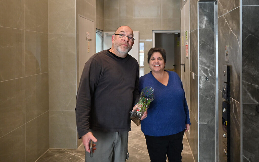 Maya Argov et Jonathan Dekel-Chen entrent dans un immeuble où résident des survivants du kibboutz Nir Oz, à Kiryat Gat, le 3 janvier 2024. (Crédit : Canaan Lidor/Times of Israel)